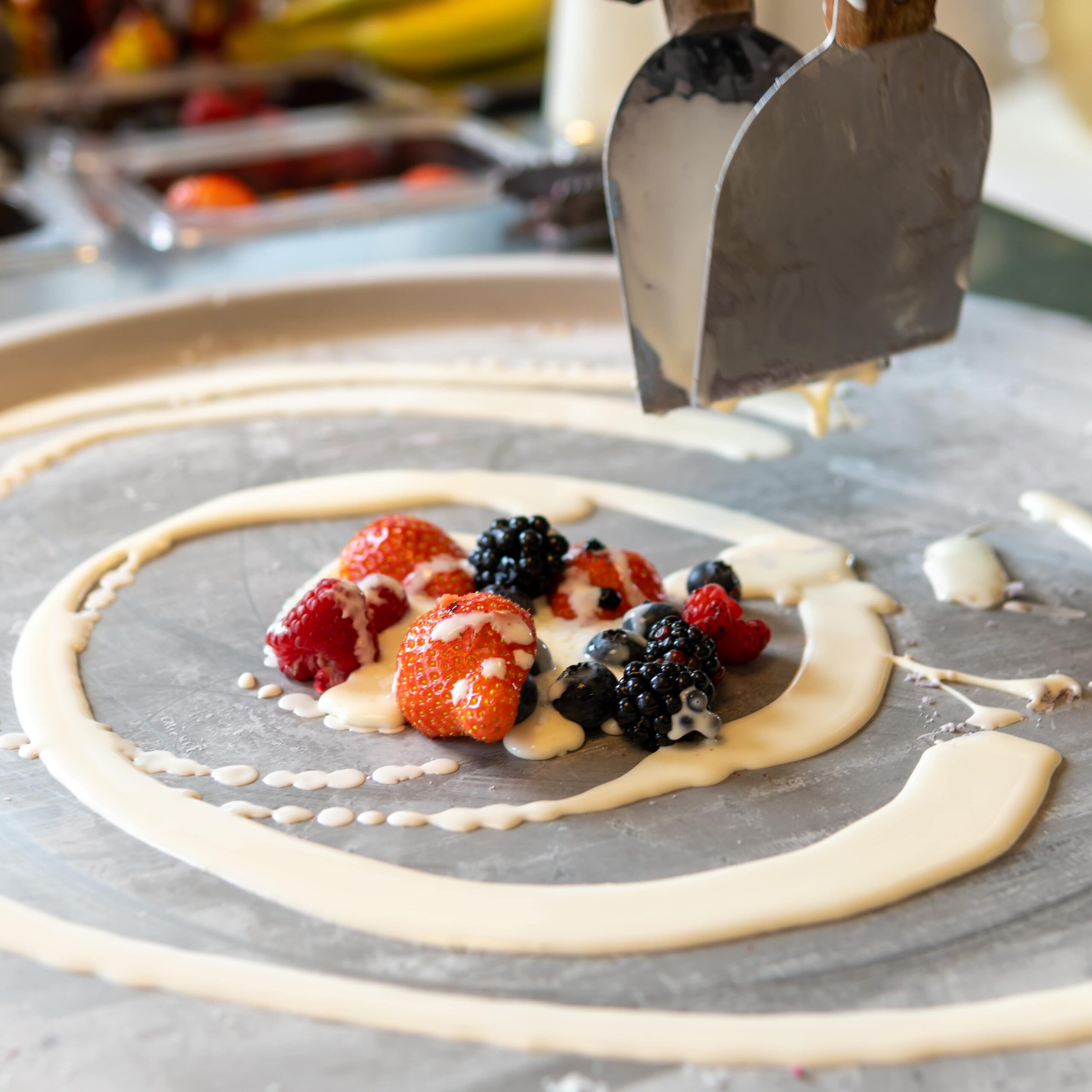 Vers fruit en saus op de vriesplaat voor live bereide Ice Cream Rolls van Loopers